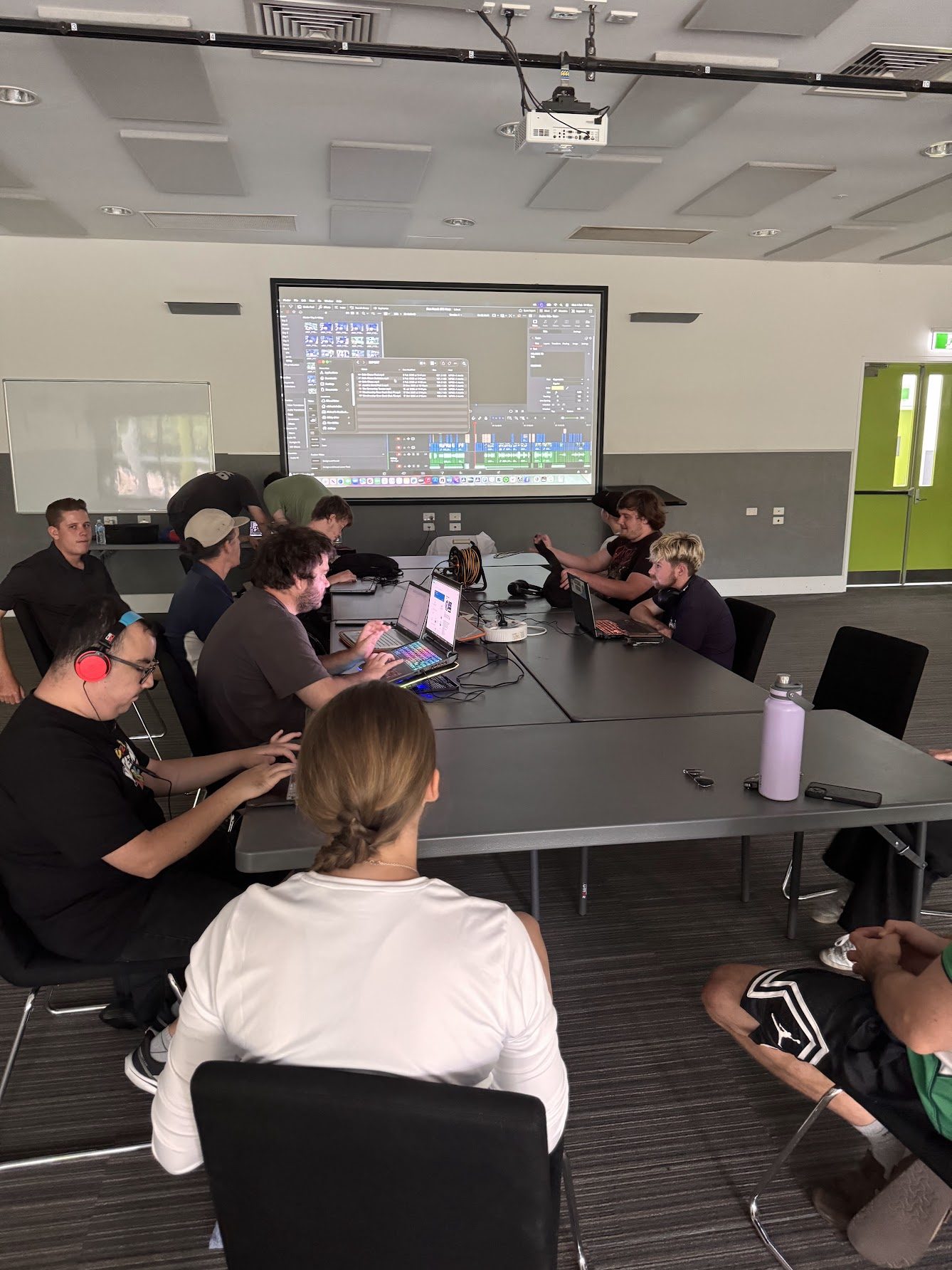 Participants in an editing session with timeline on screen